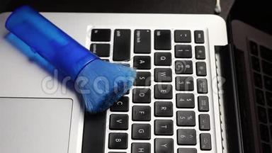 一个戴橡胶手套的人正在清洗他的笔记本<strong>电脑</strong>。 专<strong>用</strong>餐巾纸清洁笔记本<strong>电脑</strong>键盘.. 保护工作设备免受
